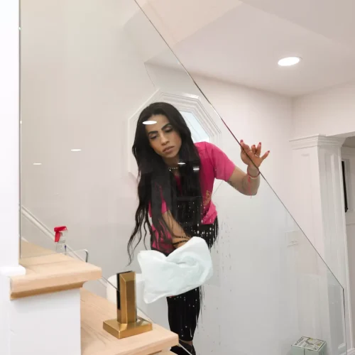 Maid vacuuming and detailing corners along a home staircase