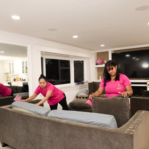 Professional cleaner dusting living room furniture in New Jersey home