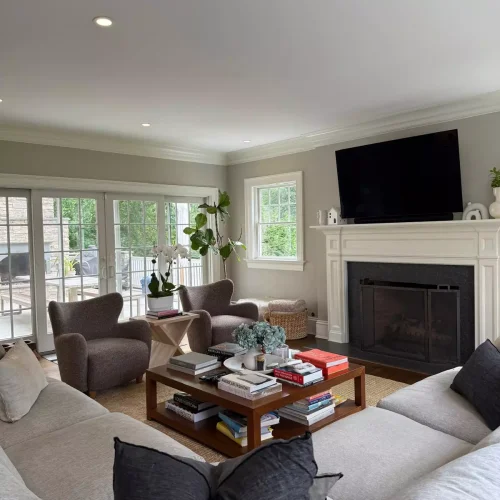 Freshly vacuumed living room carpet and dusted furniture around fireplace