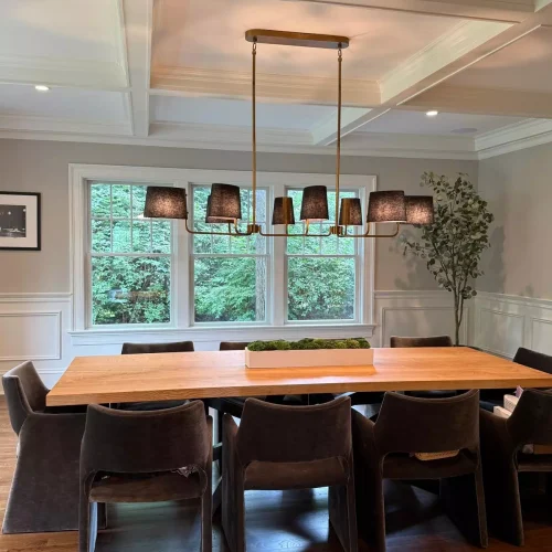 Neatly organized dining room with polished long wooden table and chairs